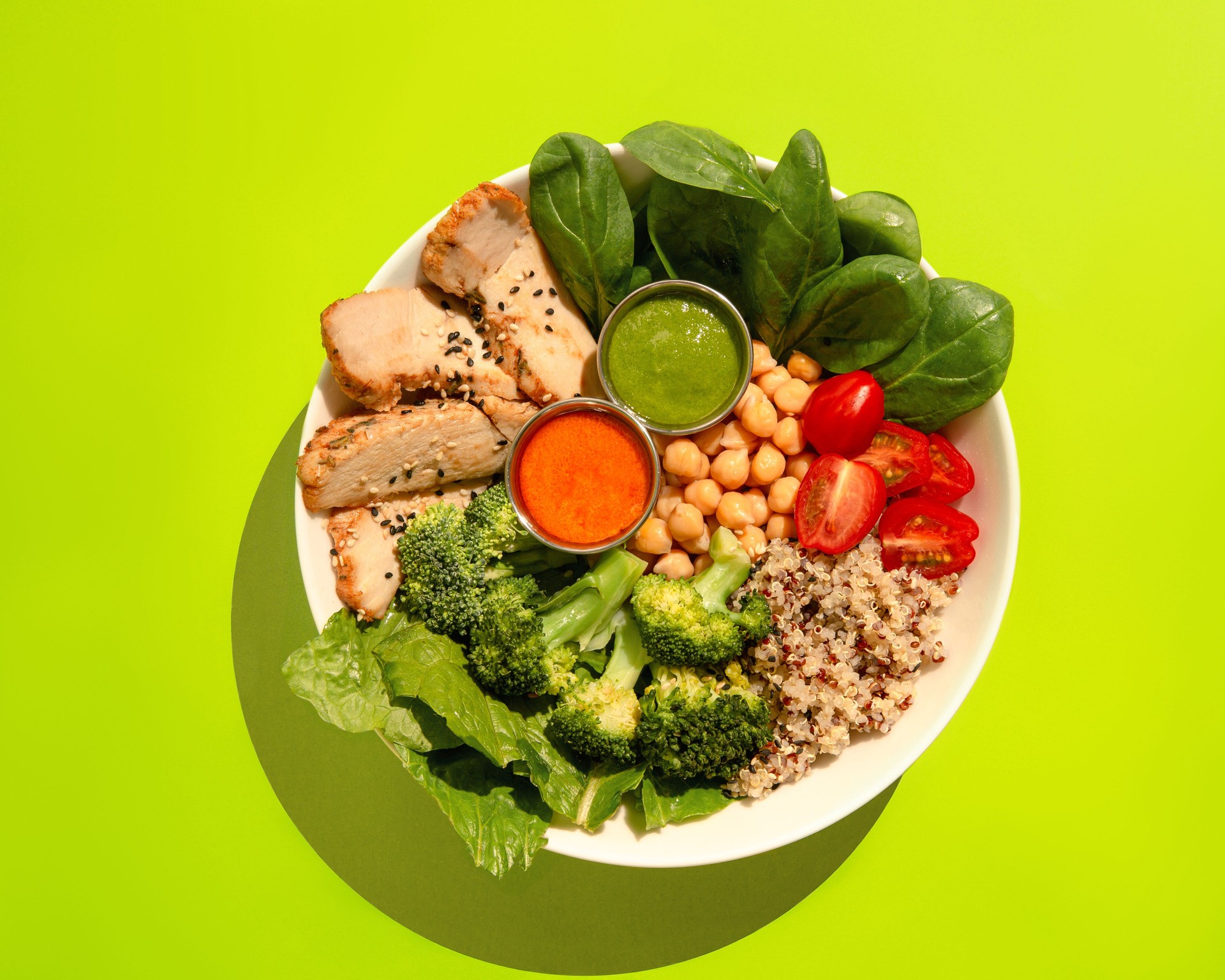 Poke bowl with chicken, quinoa, broccoli, chickpeas, tomato and spinach. Top view.
