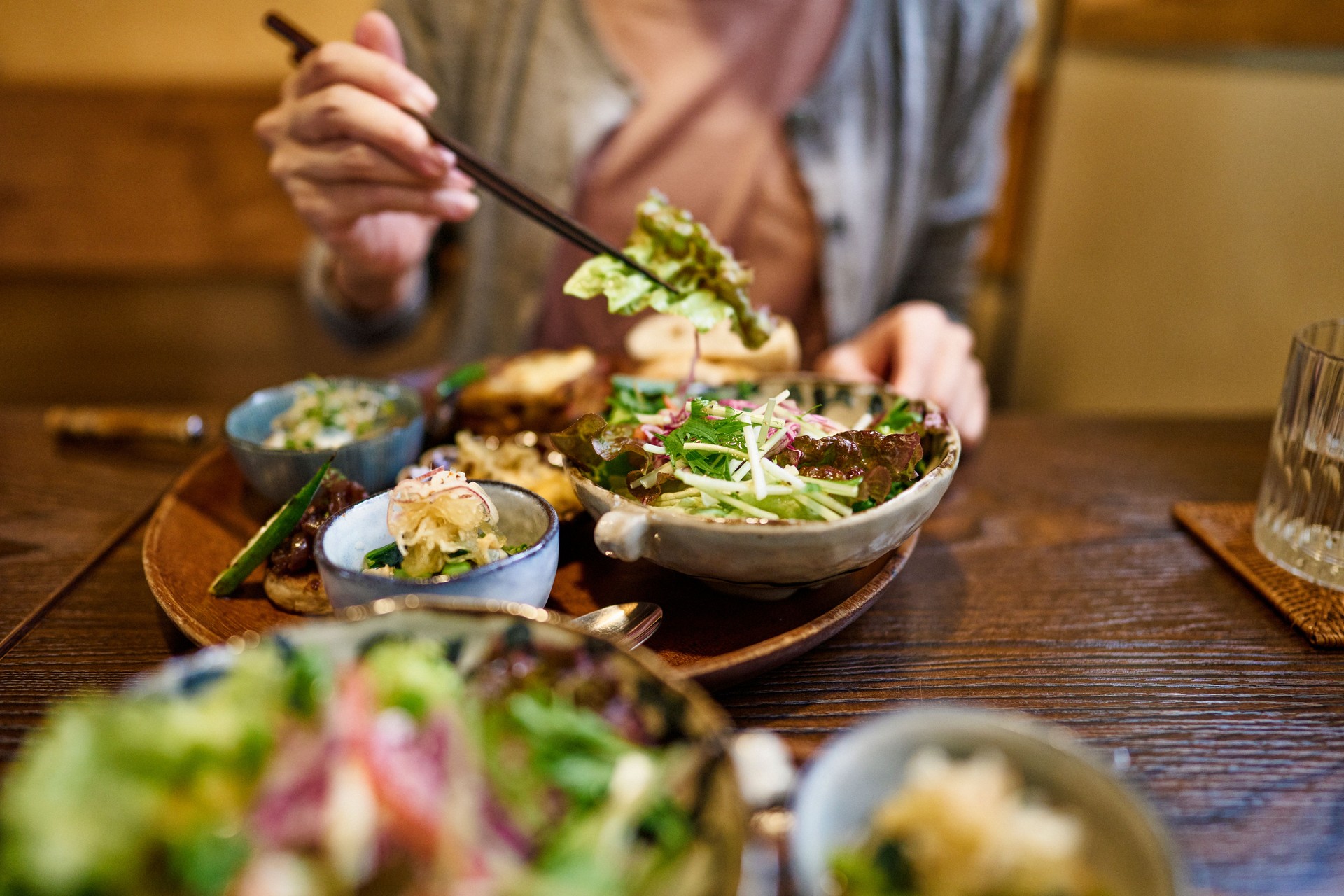 Close-up of an Asian woman enjoying a vegan meal at a vegan restaurant.